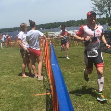 Jeff running up the finish chute with a handheld water bottle looking very tired and ready to be done. PC: Lianne Dusek
